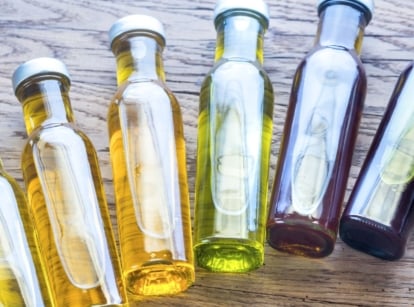 An overhead shot of bottles of different liquids that showcases the difference between horticultural oil vs neem oil